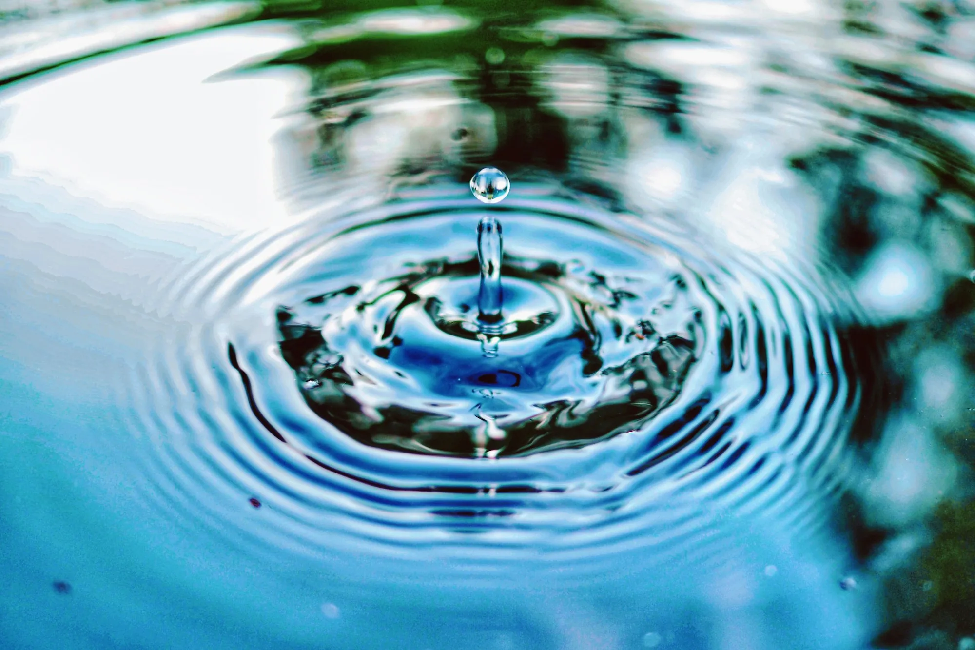 Single drop of water creating ripples on a clear surface