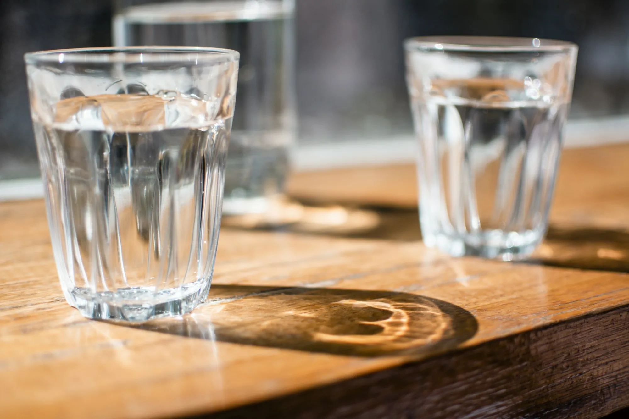 Spot-free drinking glasses of water on a wooden table