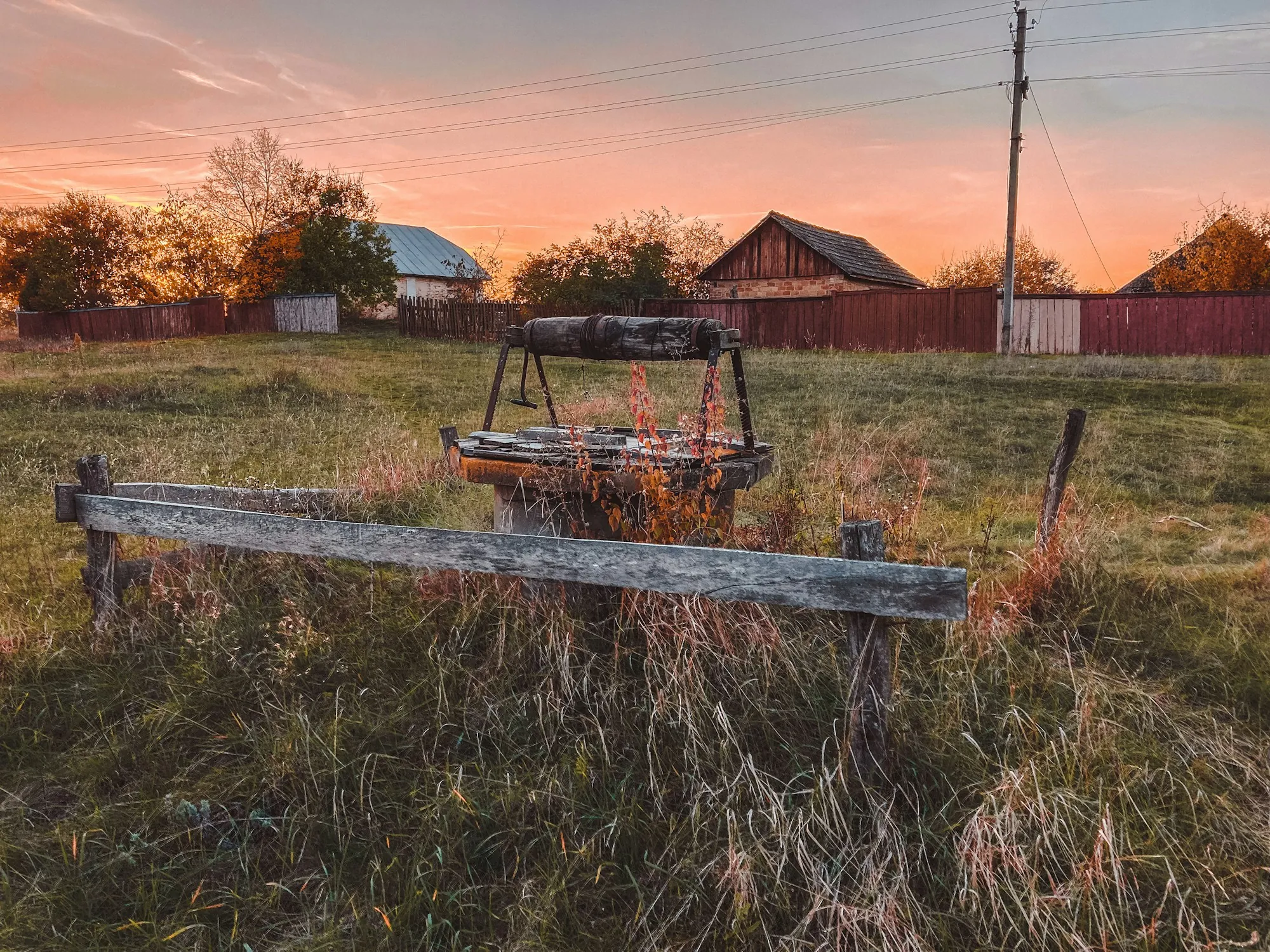 Rural property with an old well frame in an open field